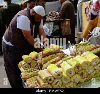 La vente du vendeur de gâteaux, souk goma (marché du vendredi), la rue du marché, le sud de cimetières, district de Khalifa ,Le Caire Banque D'Images