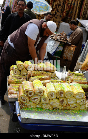 La vente du vendeur de gâteaux, souk goma (marché du vendredi), la rue du marché, le sud de cimetières, district de Khalifa ,Le Caire Banque D'Images