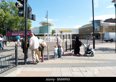 Piétons traversant la rue aux feux de signalisation et femme musulmane avec pram près du supermarché Morrisons à Stratford est de Londres Angleterre UK KATHY DEWITT Banque D'Images