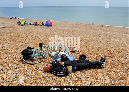 Les participants à se détendre sur la plage après avoir pris part à la balade en vélo Londres à Brighton UK Banque D'Images