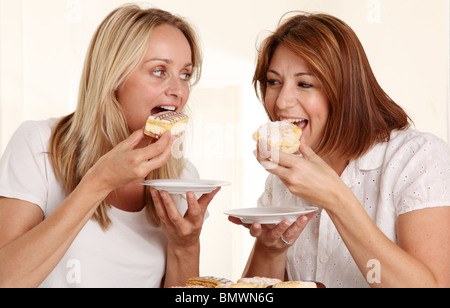Deux femmes de manger des gâteaux à la crème Banque D'Images