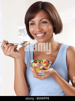 WOMAN EATING SALADE DE FRUITS FRAIS Banque D'Images