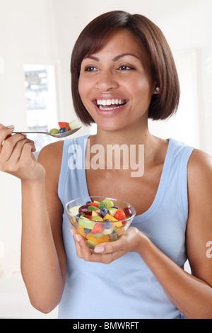 WOMAN EATING SALADE DE FRUITS FRAIS Banque D'Images