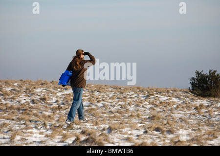 Une personne sur colline avec une mince couche de neige à / la recherche Banque D'Images