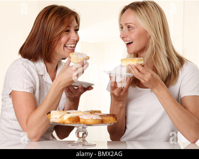 Deux femmes de manger des gâteaux à la crème Banque D'Images