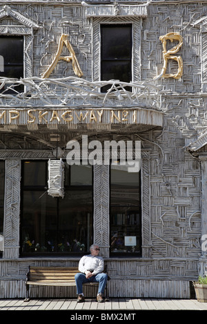 L'homme sur le banc à l'extérieur, avant boutique étrange Skagway en Alaska Banque D'Images