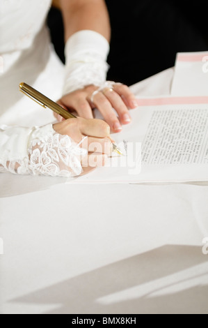 Stock photo d'un gros plan d'une épouse de signer le certificat de mariage. Banque D'Images