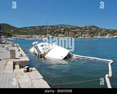 Un cabin cruiser en contrebas se trouve la moitié immergés dans un port ou le port de plaisance Banque D'Images