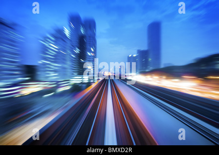 Train à grande vitesse en passant entre Kuala Lumpur ville pendant l'heure du crépuscule. L'accent sur le rail road. Banque D'Images