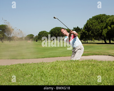 Jouer au golf, l'homme coincé dans bunker Banque D'Images