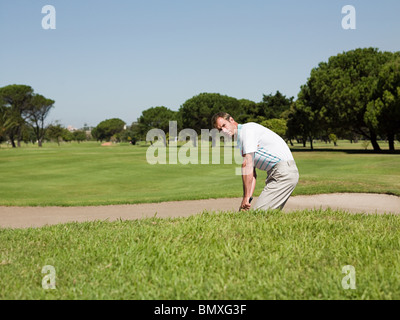 Jouer au golf, l'homme coincé dans bunker Banque D'Images