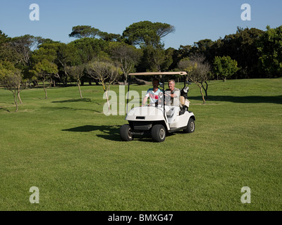 Deux hommes matures in golf cart on golf course Banque D'Images