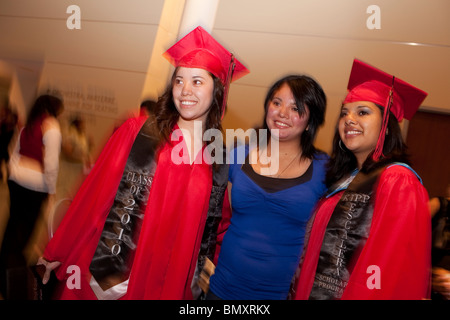 Deux diplômés de sexe féminin posent avec un invité après cérémonie de remise de diplômes à KIPP Academy high school de Houston, Texas Banque D'Images