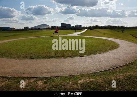 Jeune fille courir autour de Campbell Park, Milton Keynes, Buckinghamshire. Banque D'Images