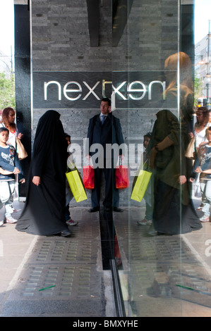 Homme avec sac rouge en face du nouveau magasin sur Oxford Street, London, UK Banque D'Images