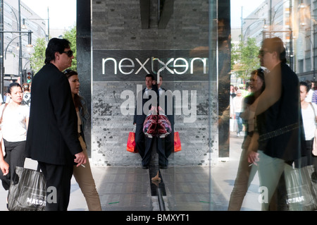 Homme avec sac rouge en face du nouveau magasin sur Oxford Street, London, UK Banque D'Images