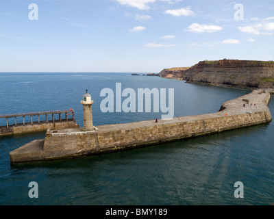 Whitby Harbour East wall et phare avec une vue vers la baie d'Saltwick prise depuis le sommet de l'Ouest phare Banque D'Images