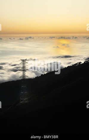 Pylône de l'électricité sur la vallée au coucher du soleil, Lomba das Torres, l'île de Madère, Portugal Banque D'Images