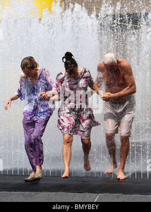 Les gens de se rafraîchir dans une fontaine à l'extérieur du Royal Festival Hall à Londres par temps chaud Banque D'Images