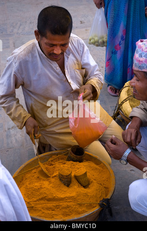 Un homme vend en poudre de curcuma orange Durbar Square, Katmandou, Népal. Banque D'Images