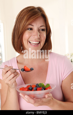 WOMAN EATING SALADE DE FRUITS FRAIS Banque D'Images