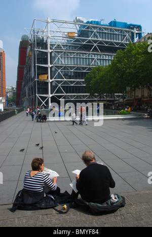 Couple Reading German language journal devant Centre Pompidou, le quartier du Marais centre de Paris France Europe Banque D'Images