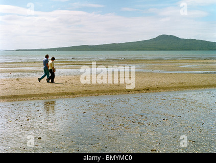 Couple en train de marcher sur la plage de la baie de St Heliers Auckland New Zealand Banque D'Images