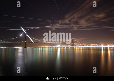 Le chemin du croissant de la lune comme il se couche sur le pont Ponte 25 de Abril à Lisbonne, Portugal. Banque D'Images