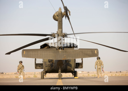 Les chefs d'équipage se placer à côté de leur UH-60L Black Hawk. Banque D'Images
