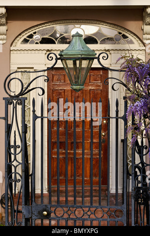 Lampe à gaz, porte en fer forgé et les glycines en face de la porte de la maison sur East Bay Street à Charleston, Caroline du Sud Banque D'Images