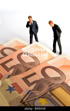 Les hommes d'affaires, figurines, et les billets en euro - argent / business / finances / investissement concept Banque D'Images