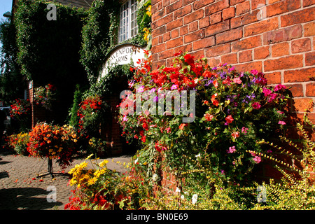 Royaume-uni, Angleterre, Stockport, Cheshire, Woodford, Davenport Arms Pub (cou du voleur) affichage Floral autour de porte Banque D'Images