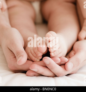 Mixed Race Mother holding Baby Boy's feet Banque D'Images