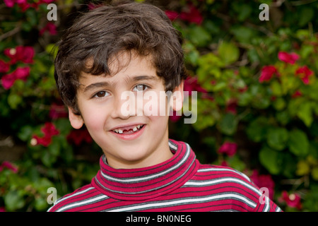 Les jeunes 6-7 ans Persan/patrimoine iranien garçon avec deux dents manquantes. M. © Myrleen Pearson Banque D'Images