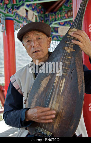 Homme jouant de la Pipa ou luth chinois Chine Yunnan Shiguzhen Banque D'Images