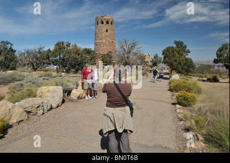 Woman taking photo pour les touristes en face de la tour de guet à Desert View, Grand Canyon, AZ ; 080922 31471  Banque D'Images