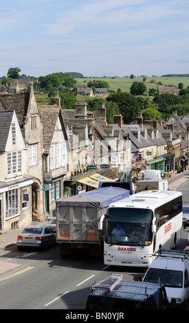 Congestion de la circulation dans la ville de Cotswolds de Burford, Oxfordshire, Royaume-Uni où un bus touristique et une camion à grains presque enfermés ensemble. Banque D'Images