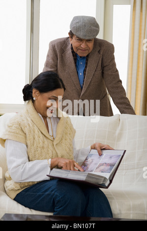 Couple de regarder un album photo Banque D'Images