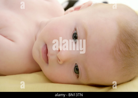 Petit bébé blond portant sur lit horizontal de l'image portrait Banque D'Images