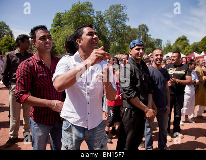 Foule heureuse d'origine asiatique pour la plupart des jeunes hommes bénéficiant d'une performance à Glasgow Mela 2010 Banque D'Images
