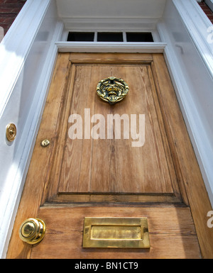 Une imposante porte avant en bois naturel de style Victorien avec des raccords en laiton poli London UK Banque D'Images