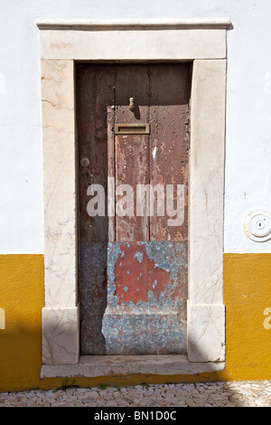 Rustique en bois rouge pâle porte de l'Europe de l'Ancien Monde contre le mur jaune Banque D'Images