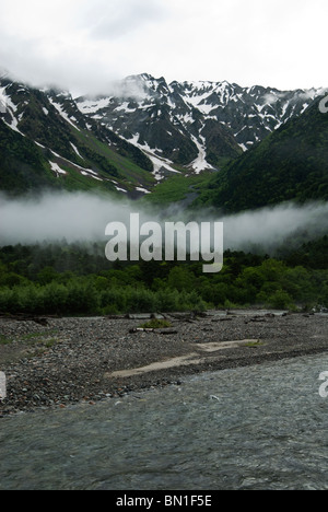 La Rivière Azusa est pris en dessous des nuages à une matinée pluvieuse dans Kamikochi. La gamme Hotaka(derrière) est neigeux, même à la fin de juin. Banque D'Images