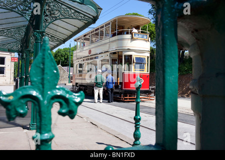 Les touristes à bord d'un tramway en face de l'ancien bâtiment de l'Assemblée Derby Chambres à Crich Tramway Museum dans le Peak District Banque D'Images