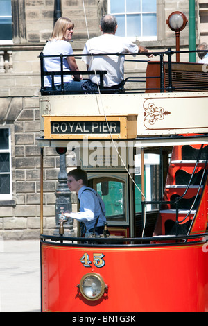 Les touristes à bord d'un tramway en face de l'ancien bâtiment de l'Assemblée Derby Chambres à Crich Tramway Museum dans le Peak District Banque D'Images