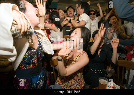 Les supporters de football sud-coréen à célébrer leur notation de l'équipe contre l'Uruguay dans un pub de Londres pendant la Coupe du Monde 2010 Banque D'Images