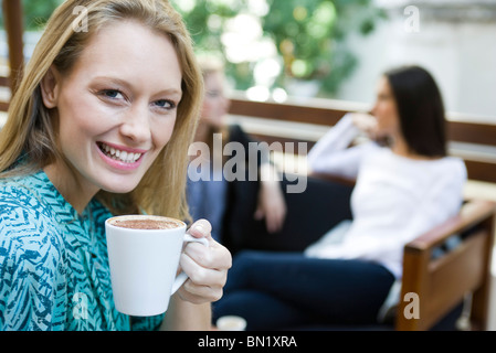 Young woman enjoying cup of coffee, portrait Banque D'Images