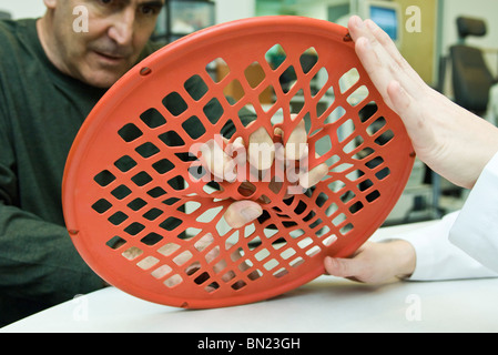 Patient en utilisant l'exercice main web pour traitement d'ergothérapie Banque D'Images