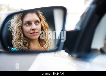 Jeune femme au volant voiture, reflet dans rétroviseur Banque D'Images