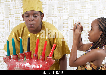 African American boy blowing out candles Kwanzaa Banque D'Images